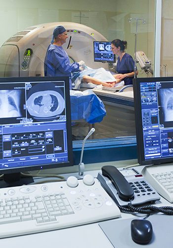 MRI machine and screens with doctor and nurse